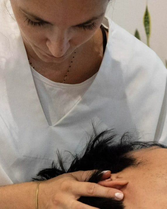 Olivia Brébant, ostéopathe, réalise une technique crânienne sur un patient allongé dans son cabinet du Piton Saint-Leu